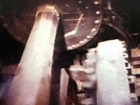 Study how a series of gears in a waterwheel translates a stream's energy to a millstone