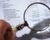 Magnifying glass on financial report.